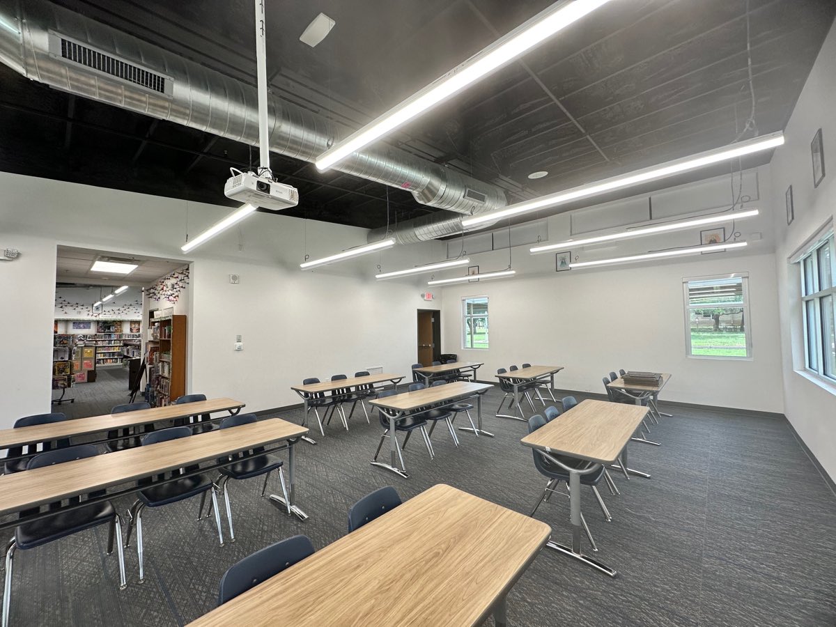 Before: folding tables across the full width of the room, the doorway to the elementary library beyond.