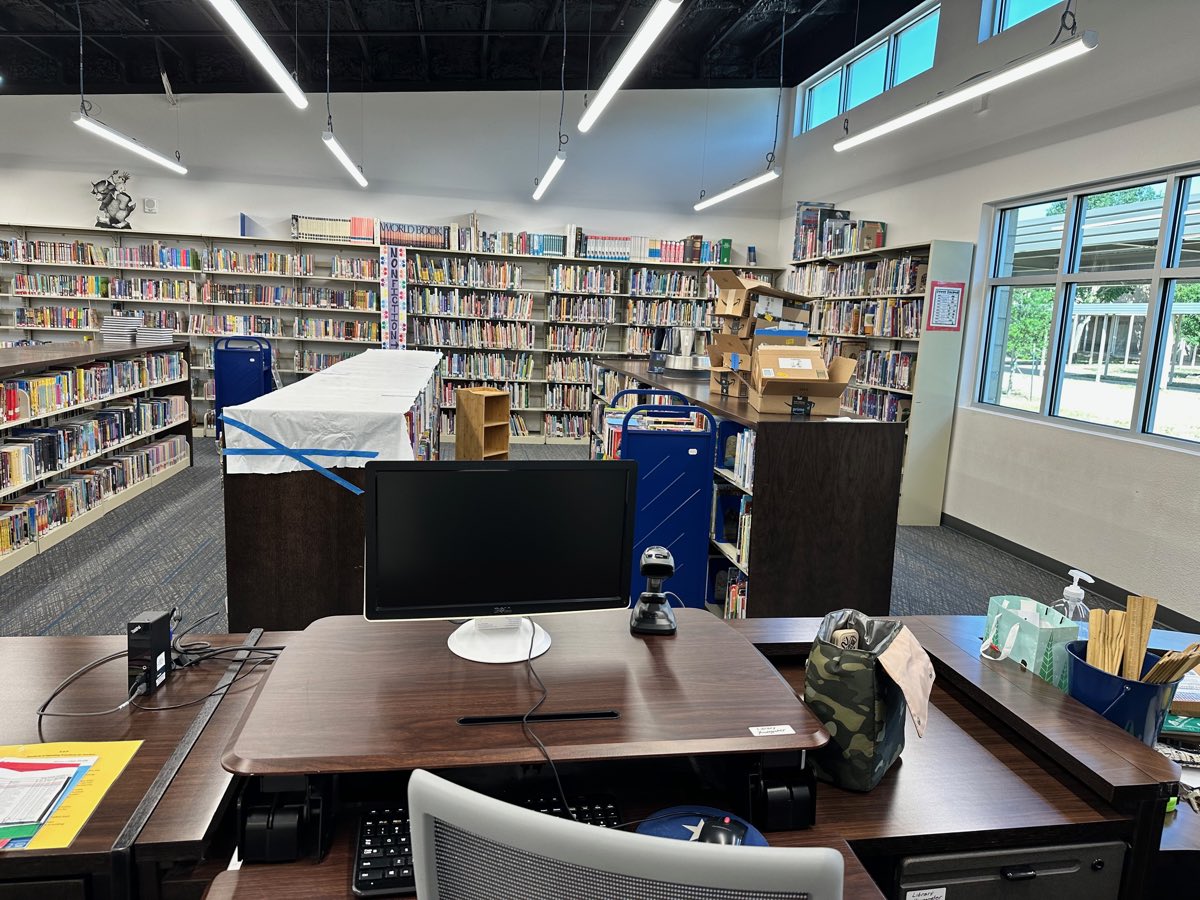 Before: a taped-over display table, delivery boxes stacked on the counter, bare walls above the stacks.