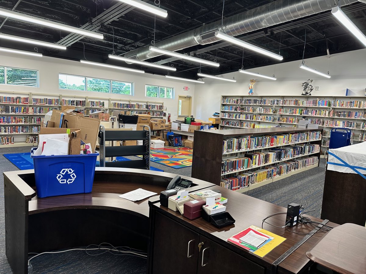 Before: cardboard and file boxes across the floor and carts, an alphabet rug, no signage anywhere.