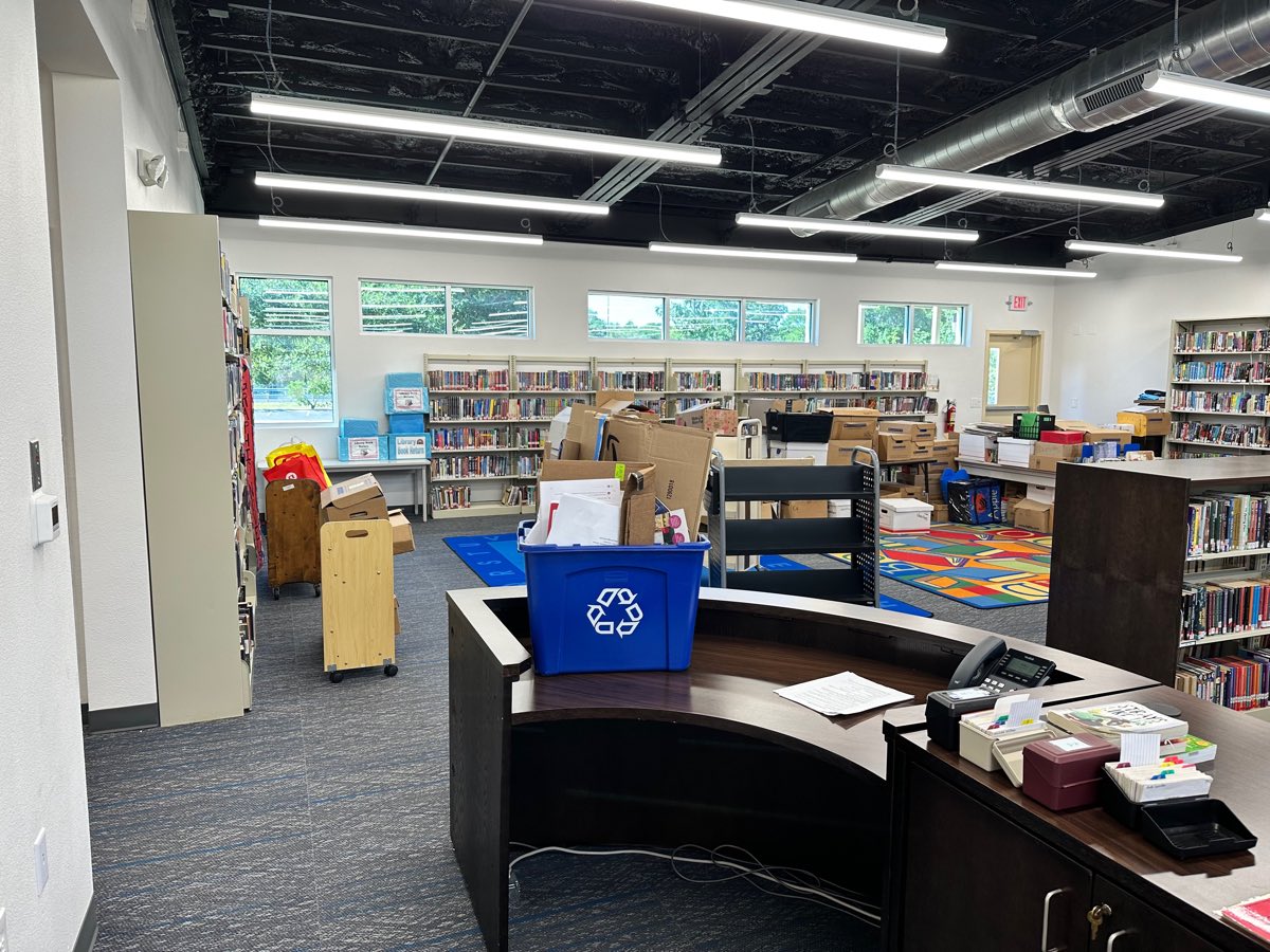 Before: a recycling bin of loose paper on the desk, boxes along the far wall, nothing on the walls.