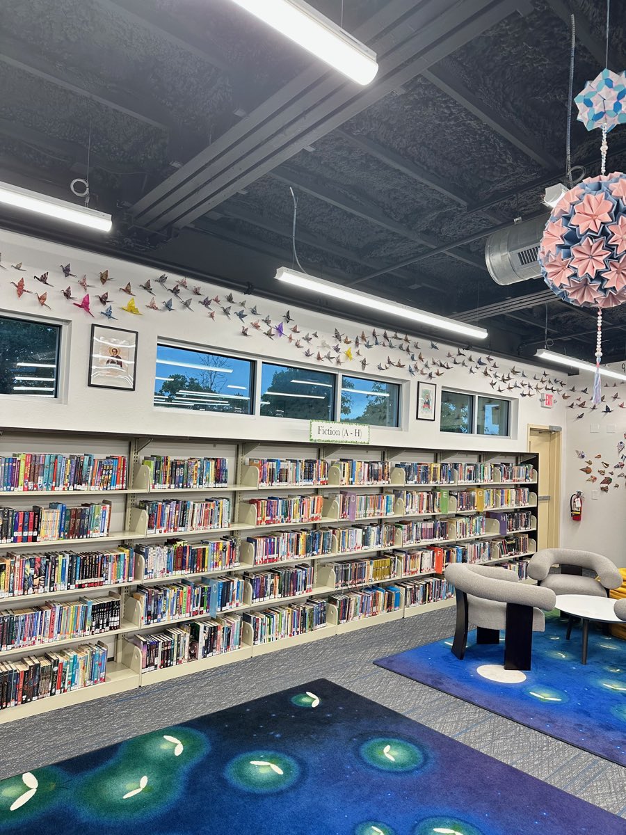 Fiction A to H beneath a stream of cranes, a pink and blue kusudama hanging over the firefly carpet.