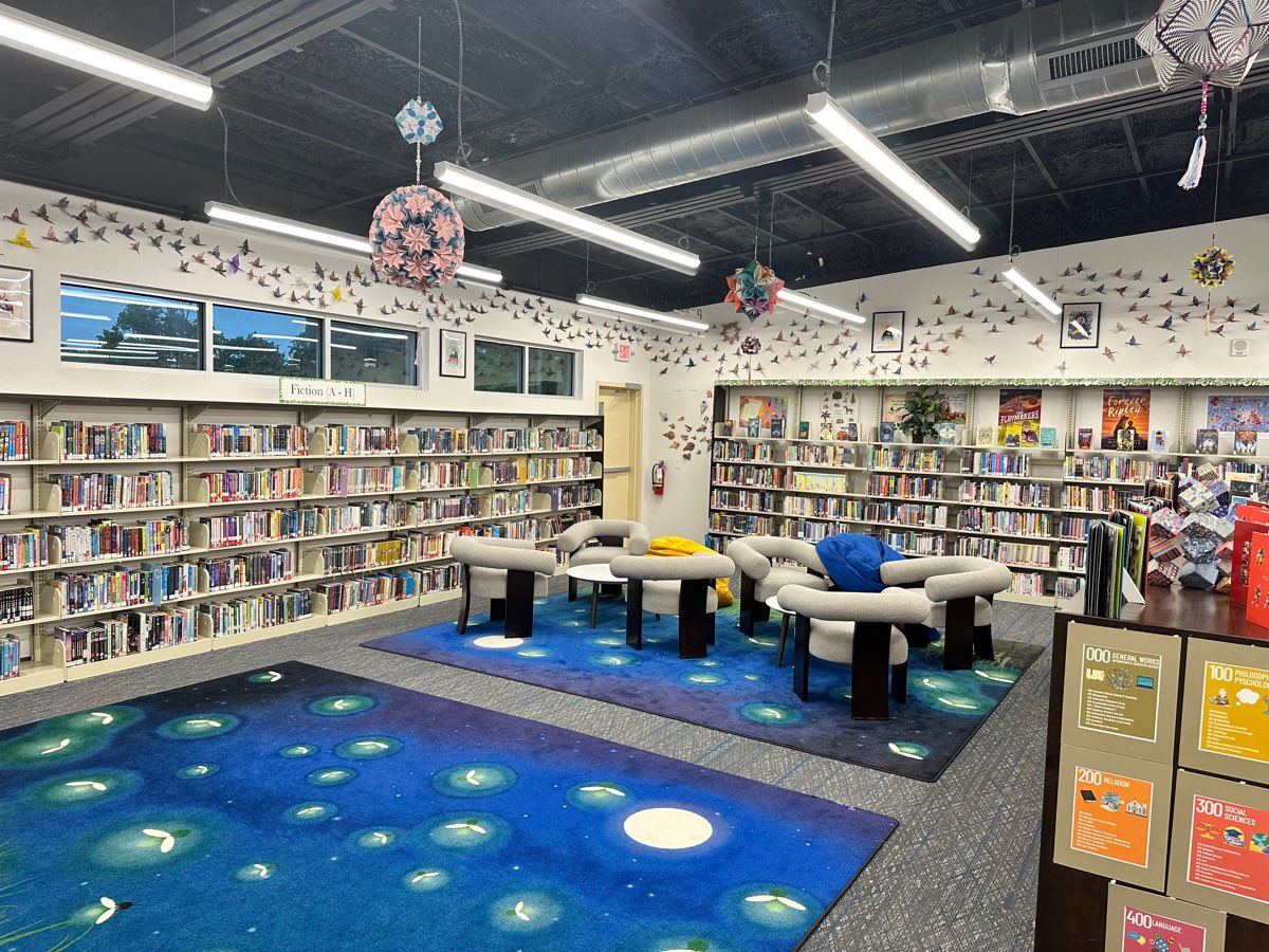 After: cranes streaming across the walls and ceiling, kusudama spheres hanging above firefly carpets and soft seating.